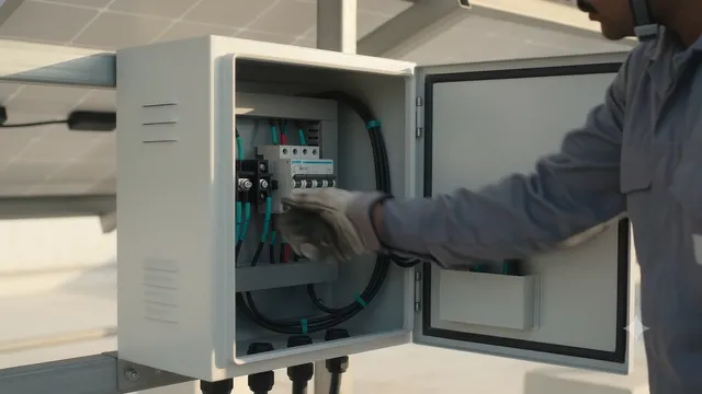 A gloved technician routing DC cables along the rails beneath the panels, then working inside an open combiner box.